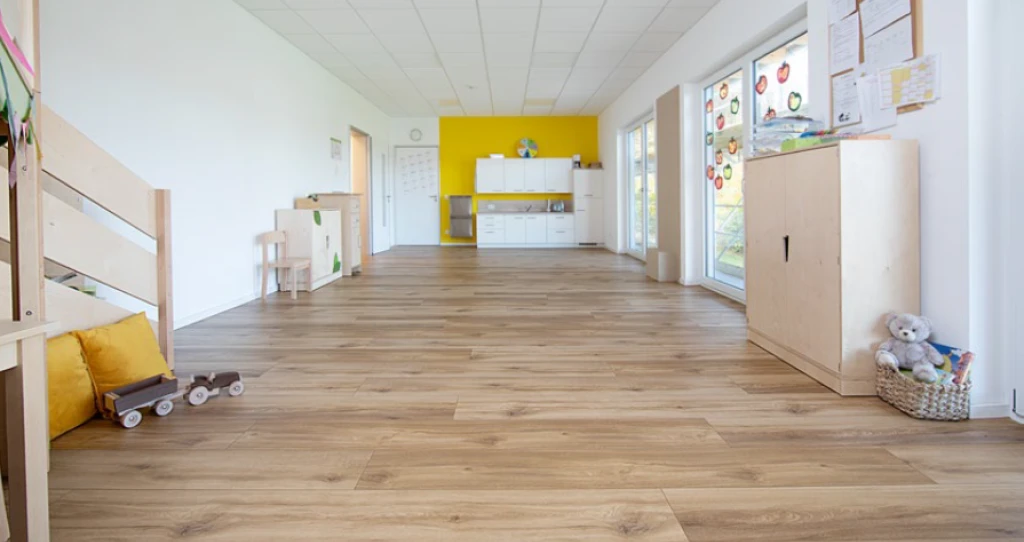 Grâce aux baies vitrées, l’espace repas et sa cuisine sont baignés de lumière et offrent suffisamment de place pour accueillir deux groupes d’enfants.