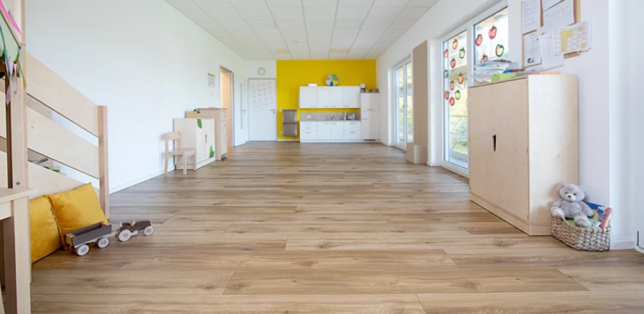 Grâce aux baies vitrées, l’espace repas et sa cuisine sont baignés de lumière et offrent suffisamment de place pour accueillir deux groupes d’enfants.