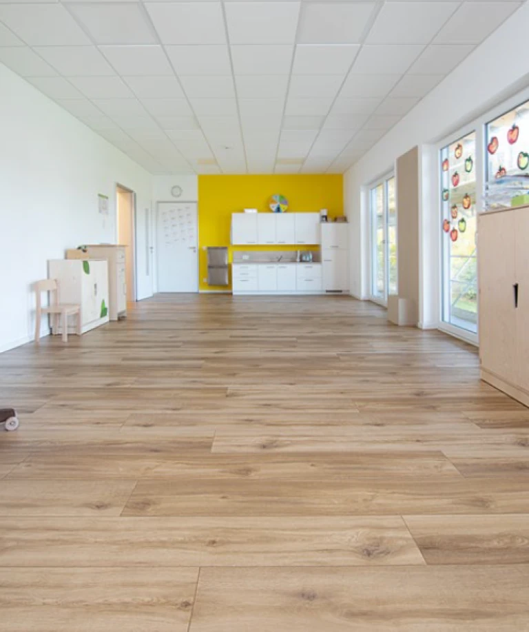 Grâce aux baies vitrées, l’espace repas et sa cuisine sont baignés de lumière et offrent suffisamment de place pour accueillir deux groupes d’enfants.