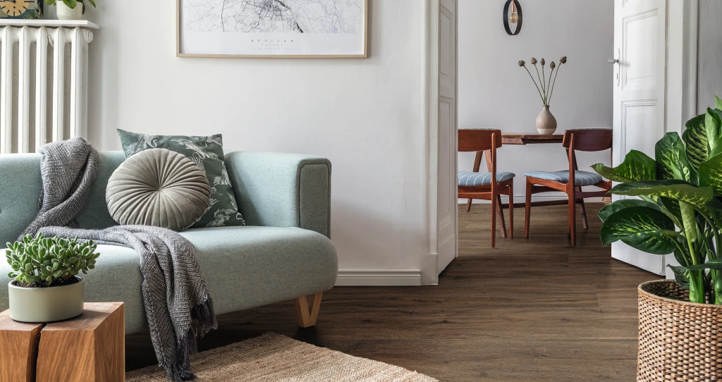 Apartamento minimalista con suelo de diseño HARO marrón. Sutiles acentos verdes en la decoración crean un ambiente fresco y natural.