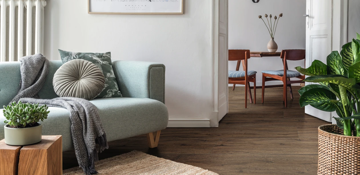 Apartamento minimalista con suelo de diseño HARO marrón. Sutiles acentos verdes en la decoración crean un ambiente fresco y natural.