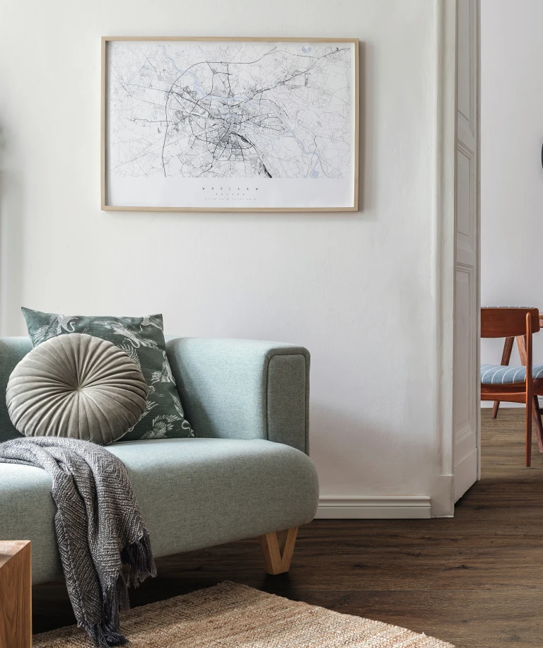 Apartamento minimalista con suelo de diseño HARO marrón. Sutiles acentos verdes en la decoración crean un ambiente fresco y natural.