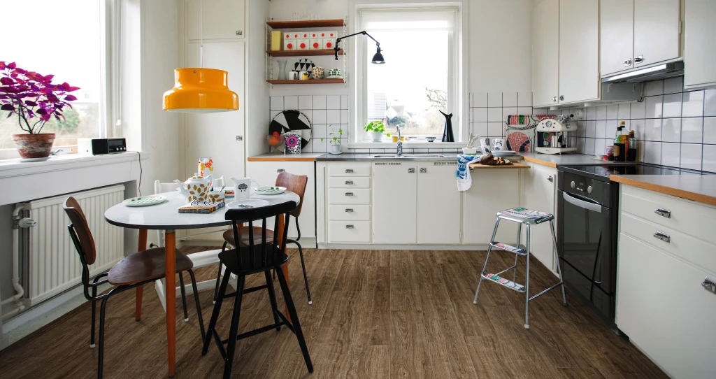 Küche mit lebendigem, oft genutztem Ambiente und braunem HARO Laminatboden. Die vielfältige Einrichtung vermittelt eine warme und einladende Atmosphäre.