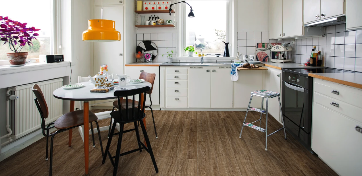 Küche mit lebendigem, oft genutztem Ambiente und braunem HARO Laminatboden. Die vielfältige Einrichtung vermittelt eine warme und einladende Atmosphäre.