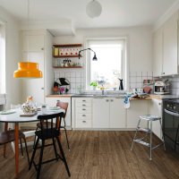 Cocina con un ambiente animado y frecuentemente utilizado, con suelo laminado HARO marrón. La decoración diversa genera una atmósfera cálida y acogedora.