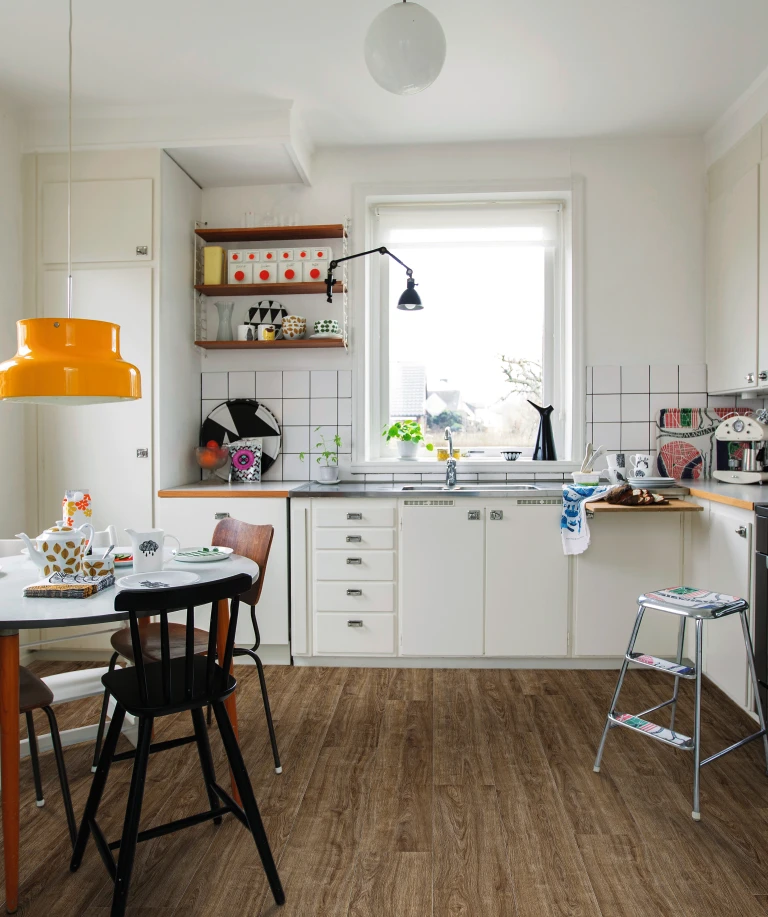 Küche mit lebendigem, oft genutztem Ambiente und braunem HARO Laminatboden. Die vielfältige Einrichtung vermittelt eine warme und einladende Atmosphäre.