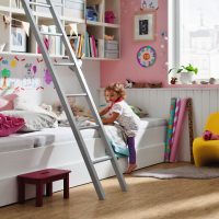 Niña pequeña jugando en su habitación sobre un suelo HARO claro: escena acogedora llena de seguridad, donde la ligereza infantil se encuentra con un diseño resistente.