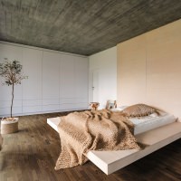 Un dormitorio acogedor y cálidamente decorado con suelo de parquet HARO oscuro, que crea un elegante contraste con el interior luminoso.