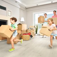 Una familia está entre cajas de mudanza en un apartamento luminoso: el momento de un nuevo comienzo en su propio hogar.