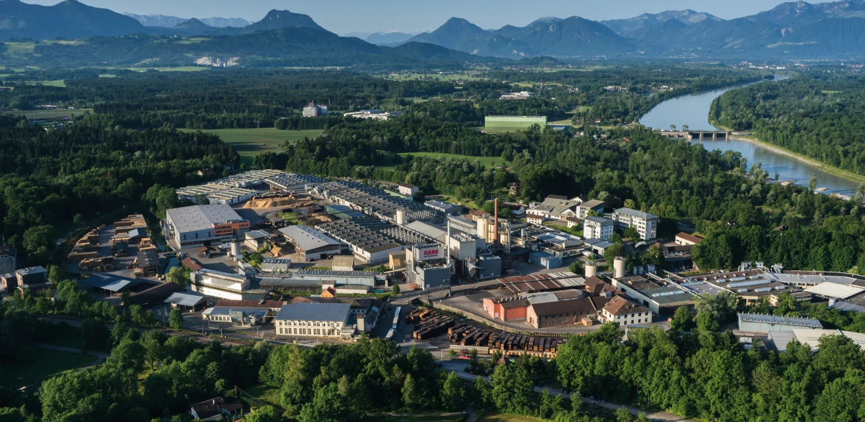 Luftaufnahme des gesamten Hamberger Firmengeländes, aufgenommen aus der Vogelperspektive mit einer Drohne; zu sehen sind Produktionshallen, Verwaltungsgebäude, Parkflächen und umliegende Grünflächen bei Tageslicht.