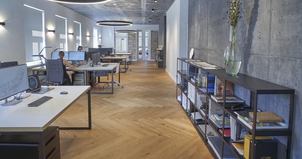 De store kontorlokaler er imponerende med det flotte miks af materialer som træ, beton og teglmurværk.