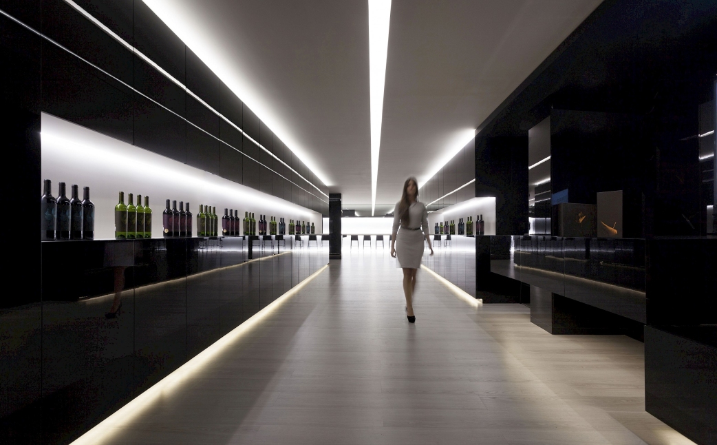 The black lacquered surfaces create a fascinating contrast with the illuminated shelving and ceilings