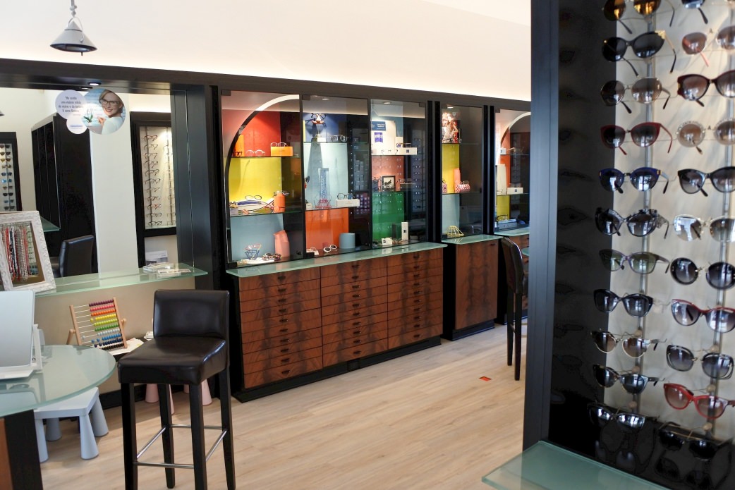 Il pavimento di design con il decoro rovere chiaro forma un bel contrasto con l’arredamento scuro del negozio