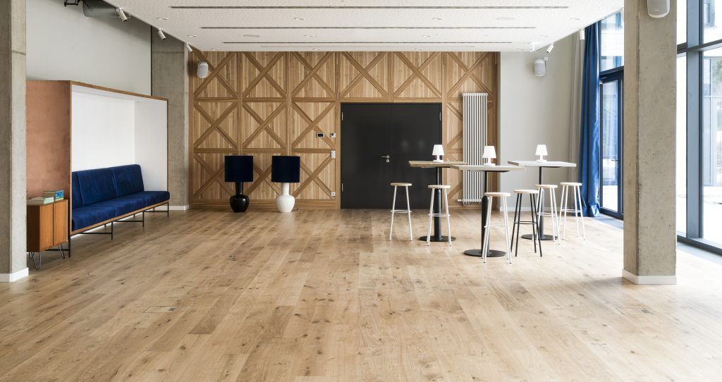 Die Bibliothek präsentiert sich hell und offen mit bodentiefen Fenstern und HARO Landhausdiele Eiche