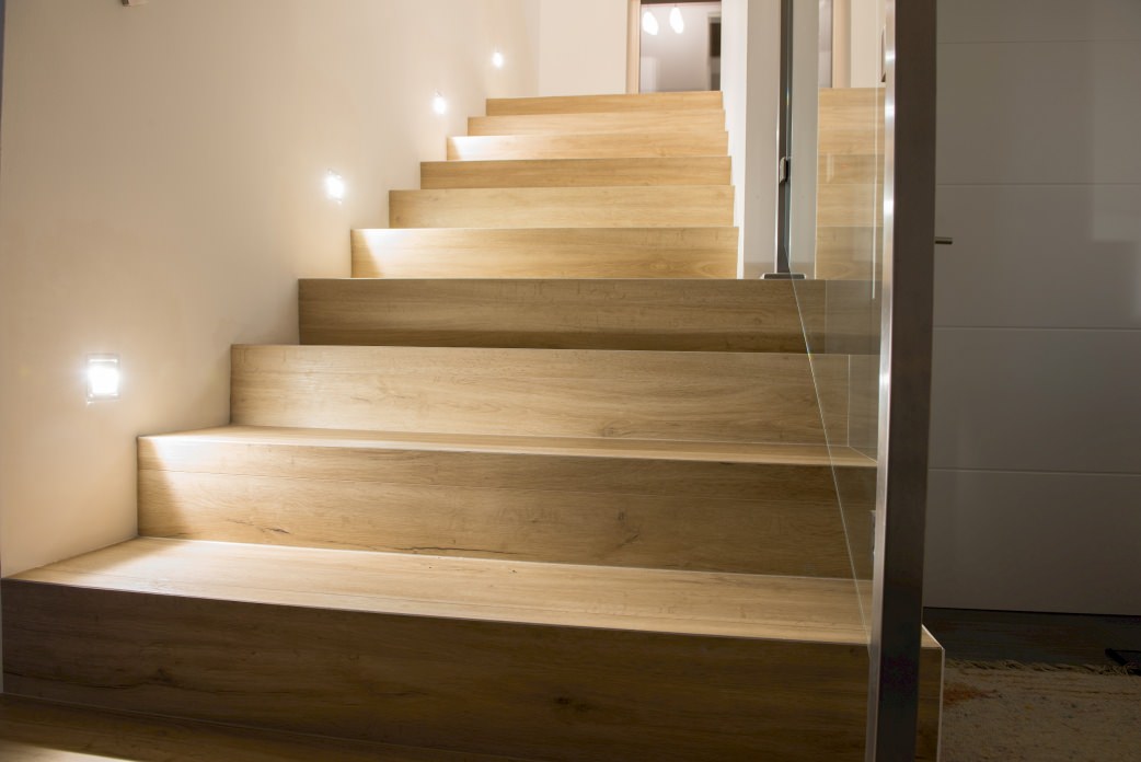 Die bodennahe Beleuchtung in der Wand bringt das Dekor Sandeiche mit seiner natürlichen, warmen Ausstrahlung bestens zur Geltung.