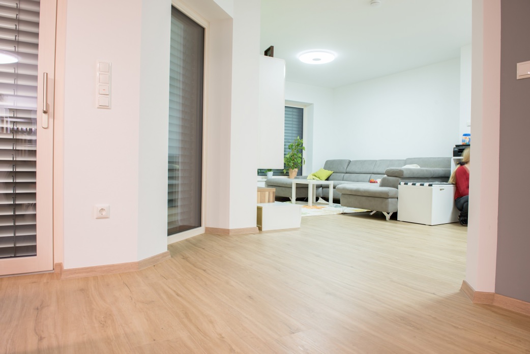 Auch im Wohnbereich harmoniert der Designboden DISANO by HARO mit dem Dekor Sandeiche bestens mit der einladenden Couch.