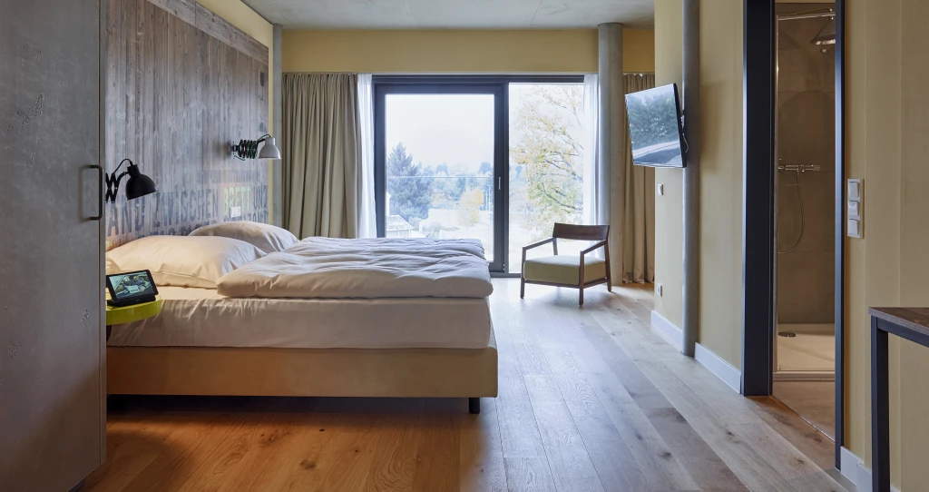 Der naturbelassene Farbton der HARO  Landhausdielen ist ein charakterstarker Blickfang in den Zimmern mit der reduzierten Einrichtung