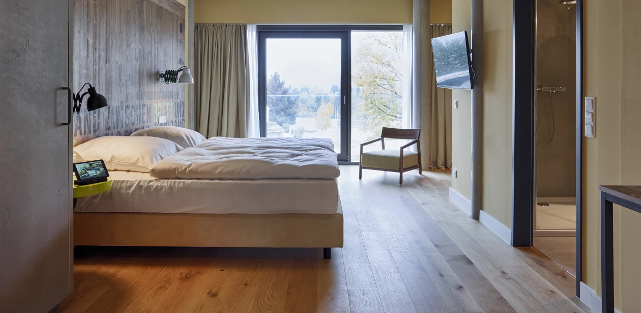 Der naturbelassene Farbton der HARO  Landhausdielen ist ein charakterstarker Blickfang in den Zimmern mit der reduzierten Einrichtung