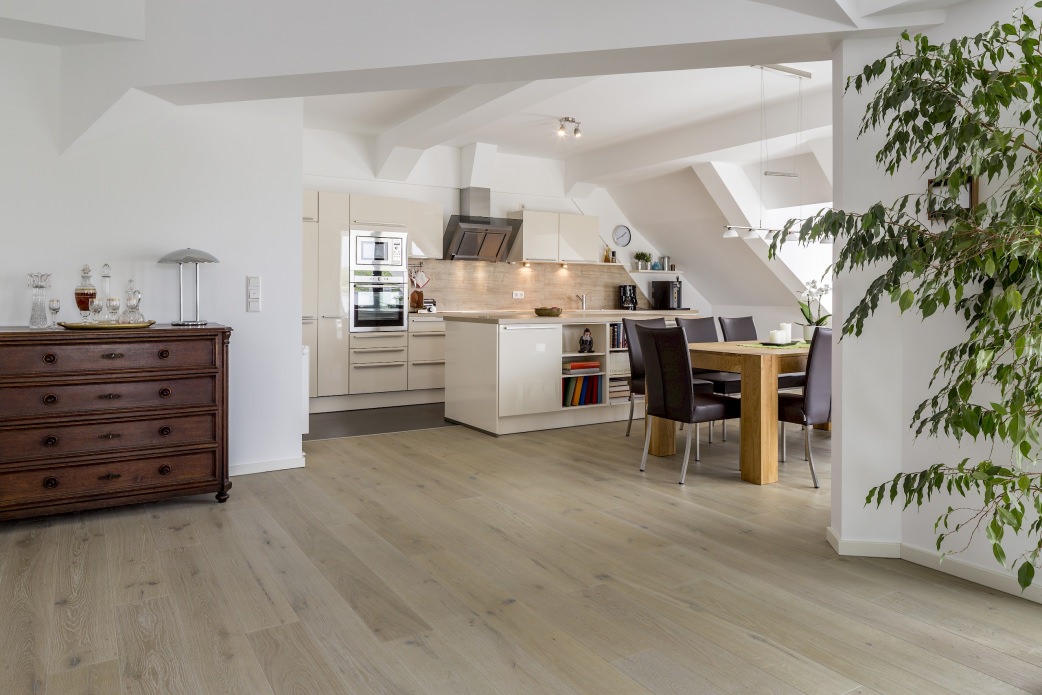 El luminoso ático consigue su acogedor ambiente en gran medida gracias al generoso suelo de 1-lama blanco crema HARO Roble Sauvage