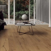 Un salón moderno con parquet HARO de color claro; en la esquina inferior izquierda se puede ver un sello "Made in Germany", un símbolo de garantía de 30 años y un certificado de originalidad: una expresión de calidad, origen y durabilidad.