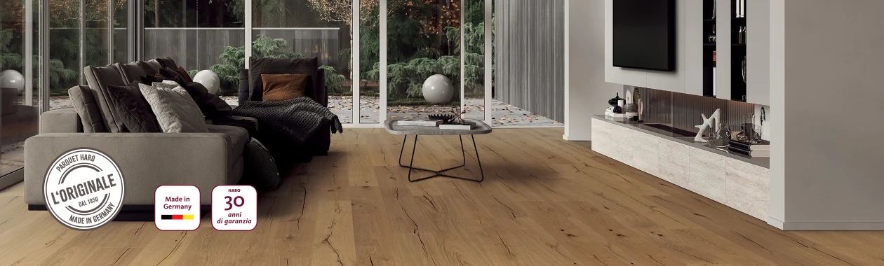 Un soggiorno moderno con pavimento in parquet HARO di colore chiaro; nell'angolo in basso a sinistra sono visibili il sigillo 