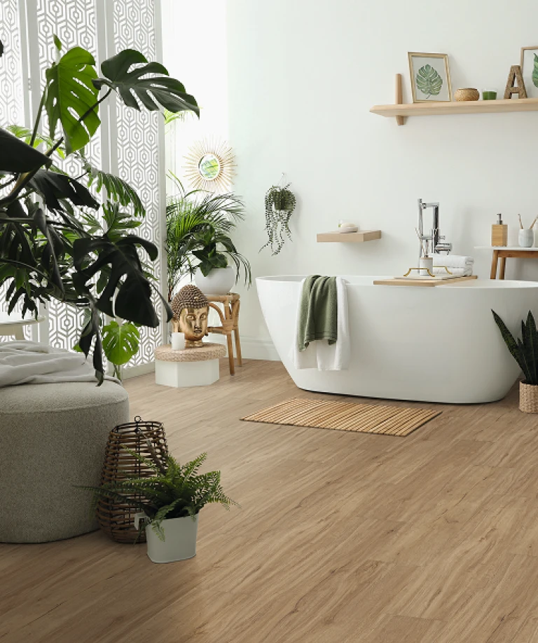 Modernes, hell eingerichtetes Badezimmer mit hellbraunem HARO Designboden; im Zentrum steht eine freistehende weiße Badewanne – zeitloses Ambiente mit wohngesunder Eleganz.