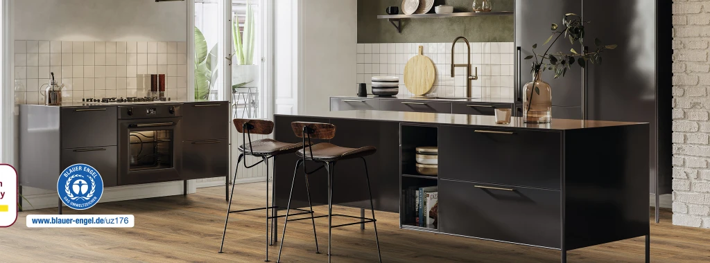 Modern kitchen with light-colored furniture and a light-reflecting HARO laminate floor in a friendly wood look. In the bottom left corner, the