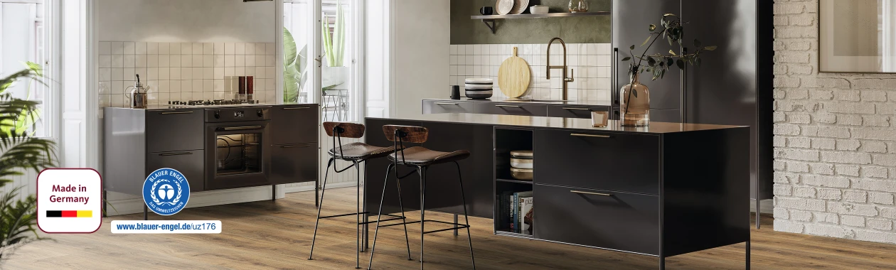 Modern kitchen with light-colored furniture and a light-reflecting HARO laminate floor in a friendly wood look. In the bottom left corner, the