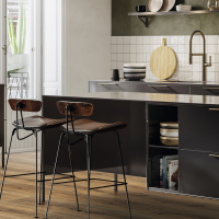 Cocina moderna con muebles claros y un suelo laminado HARO que refleja la luz, con un aspecto cálido de madera. En la esquina inferior izquierda se encuentran el sello de calidad "Made in Germany" y la etiqueta ecológica "Blauer Engel".