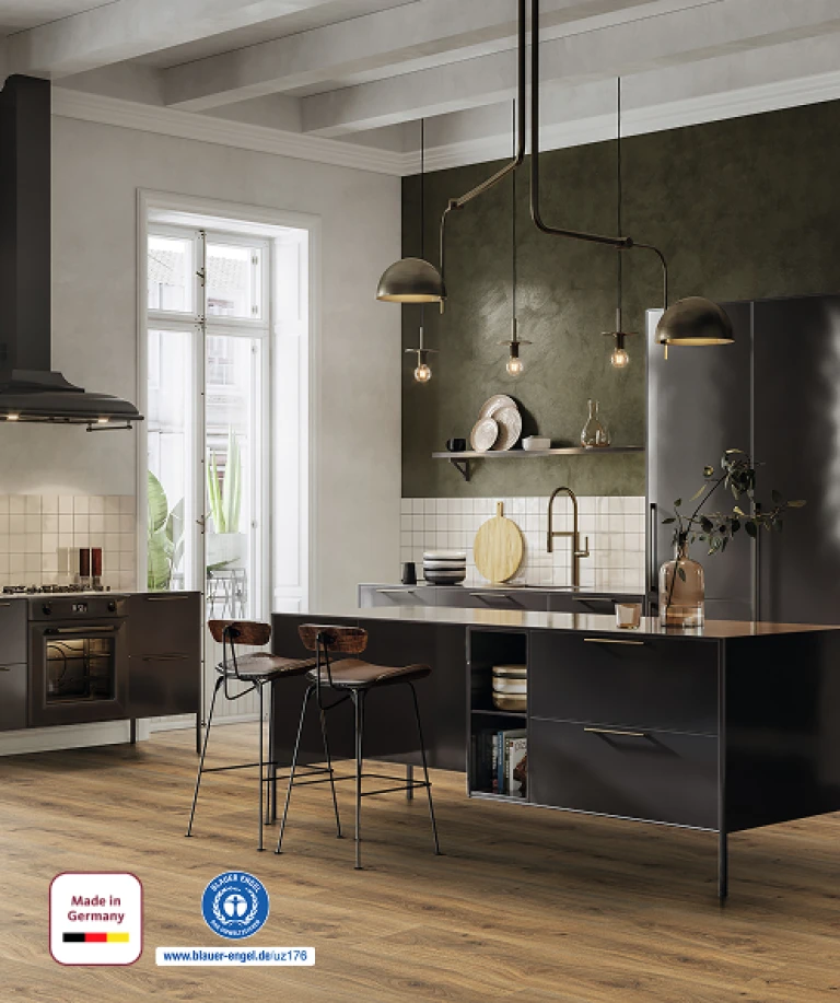 Modern kitchen with light-colored furniture and a light-reflecting HARO laminate floor in a friendly wood look. In the bottom left corner, the