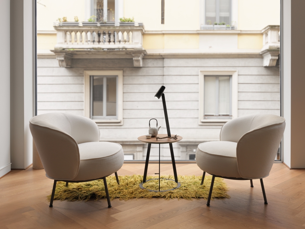 Dos sillones lounge están colocados frente a una gran fachada de ventanas. El suelo está revestido con parquet HARO marrón oscuro en espiga.