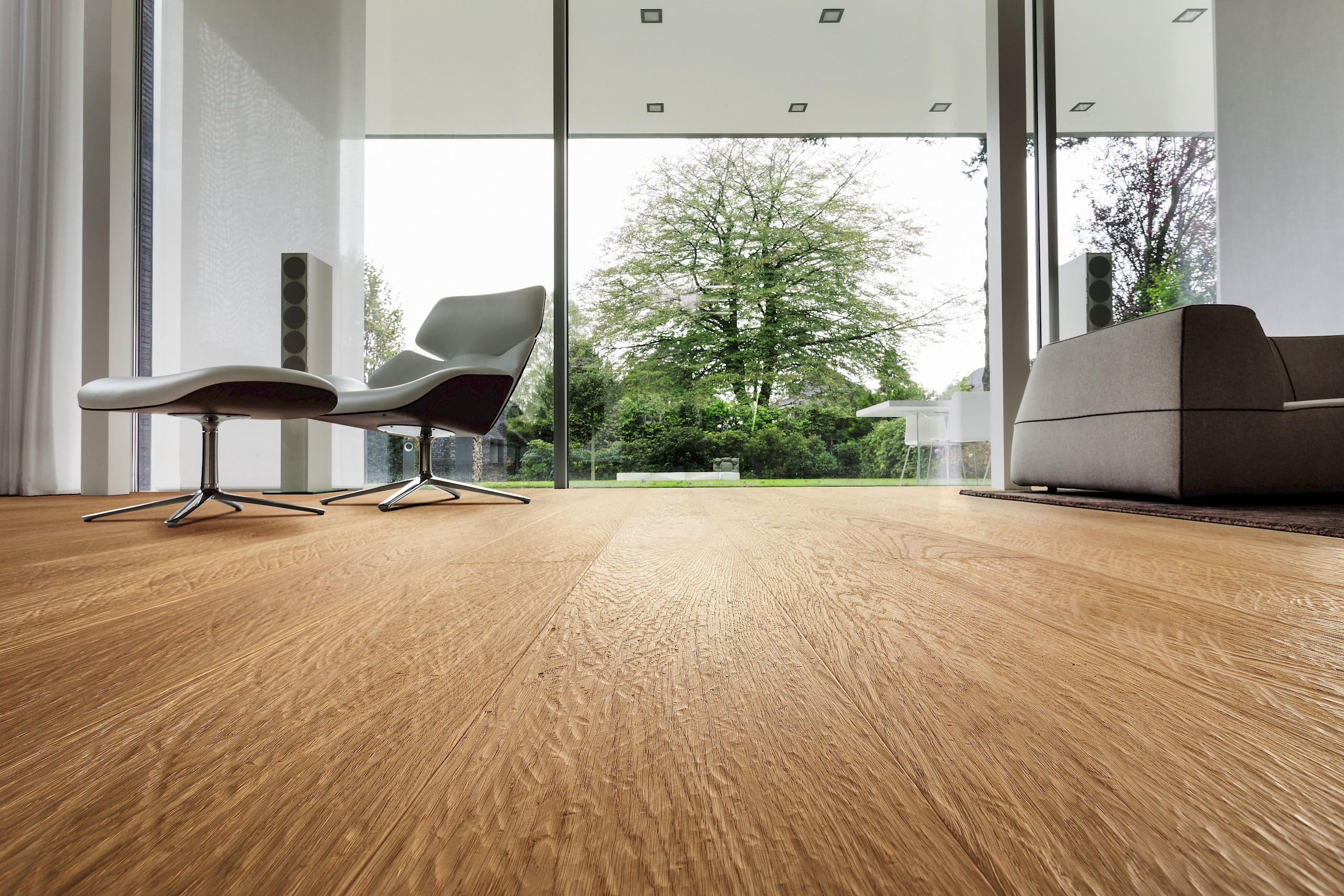 Ecke eines stilvollen Schlafzimmers mit individuell gestaltetem Parkettboden der HARO parkettmanufaktur, veredelt durch kunstvolle Einfräsungen.