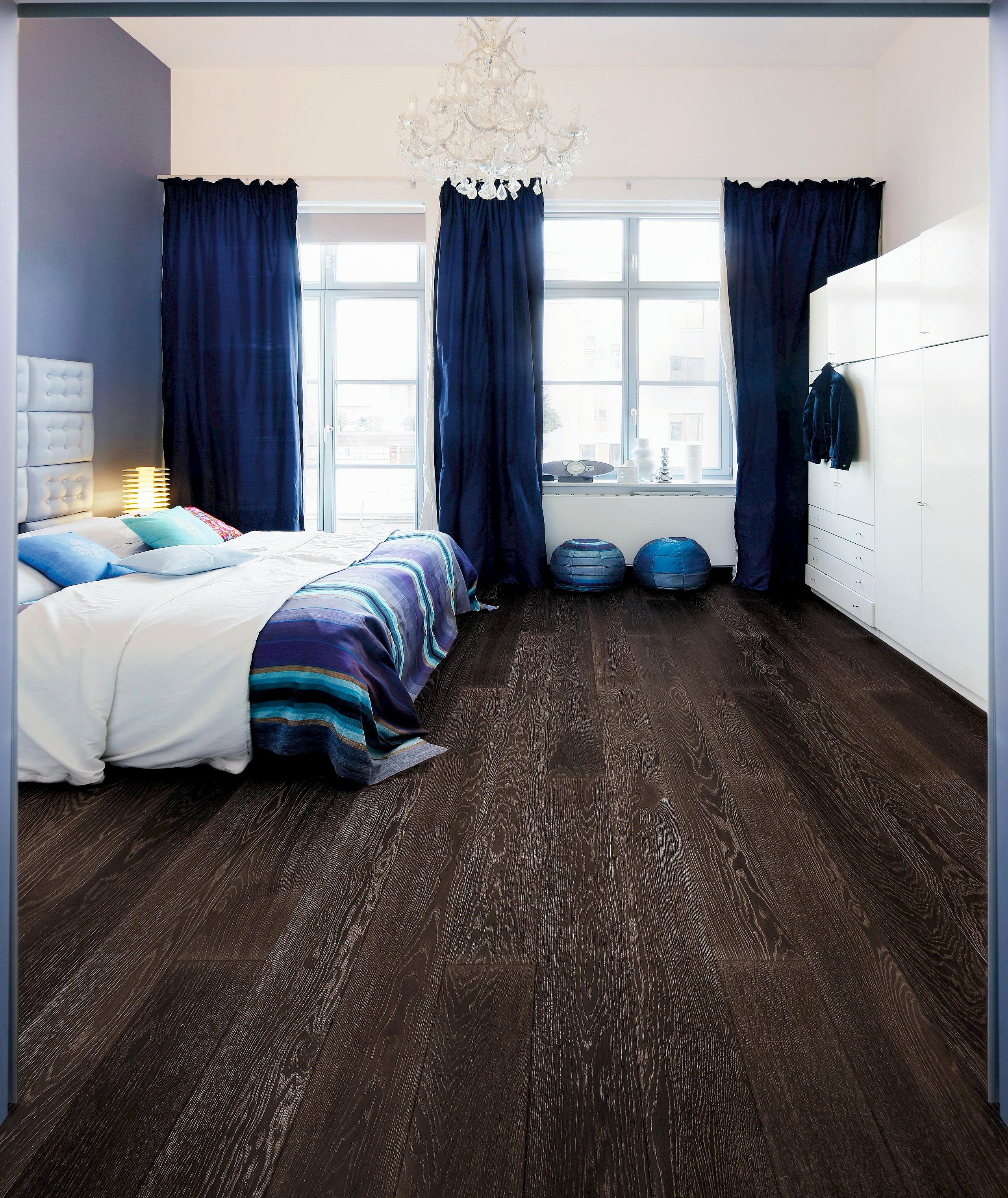 Dunkel eingerichtetes Schlafzimmer mit edlem Parkettboden der HARO parkettmanufaktur – stilvolle Gemütlichkeit trifft auf moderne Eleganz.