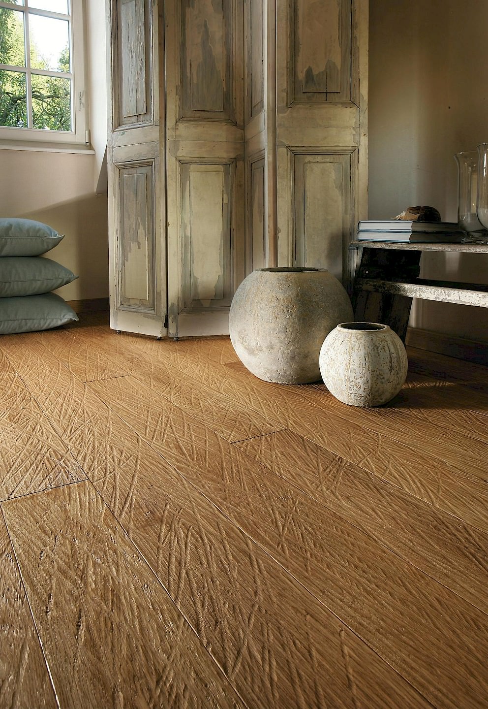 Ecke eines stilvollen Schlafzimmers mit individuell gestaltetem Parkettboden der HARO parkettmanufaktur, veredelt durch kunstvolle Einfräsungen.