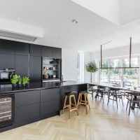 Sommerhusets stueetage er holdt i en åben stil; køkkenet, spisepladsen og stuen går over i hinanden.