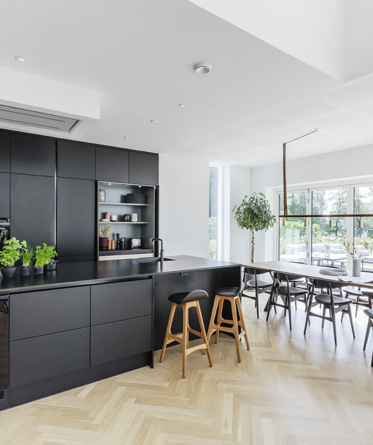 Sommerhusets stueetage er holdt i en åben stil; køkkenet, spisepladsen og stuen går over i hinanden.