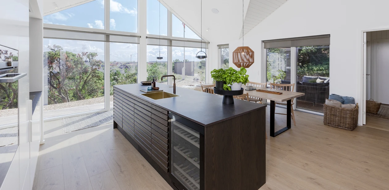 Den store køkkenø i det lyse rum indeholder håndvasken; til dette arbejdsområde er et HARO laminatgulv det perfekte valg.