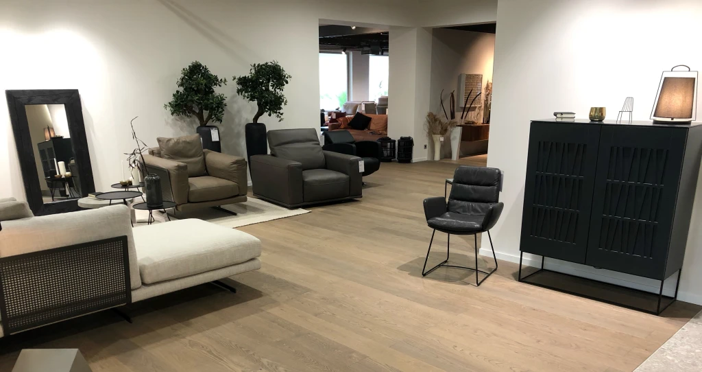 Die graue Anmutung des Parkettbodens bildet attraktive Kontraste mit den kräftigen Farben der Möbel und Sitzmöbel.