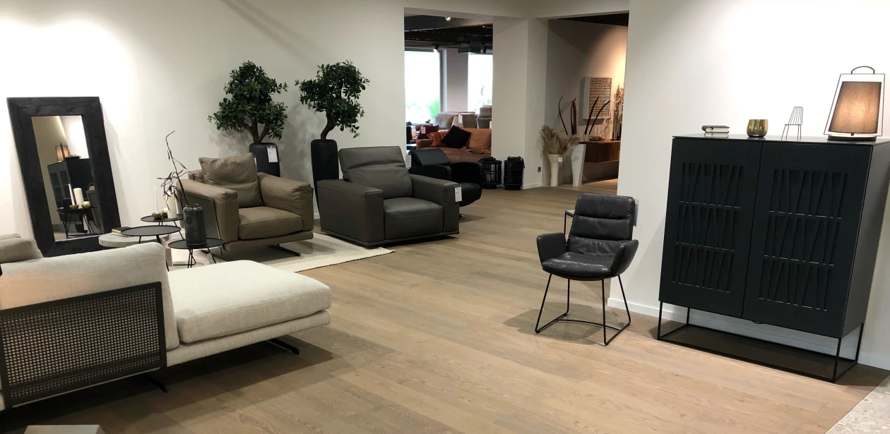 Die graue Anmutung des Parkettbodens bildet attraktive Kontraste mit den kräftigen Farben der Möbel und Sitzmöbel.