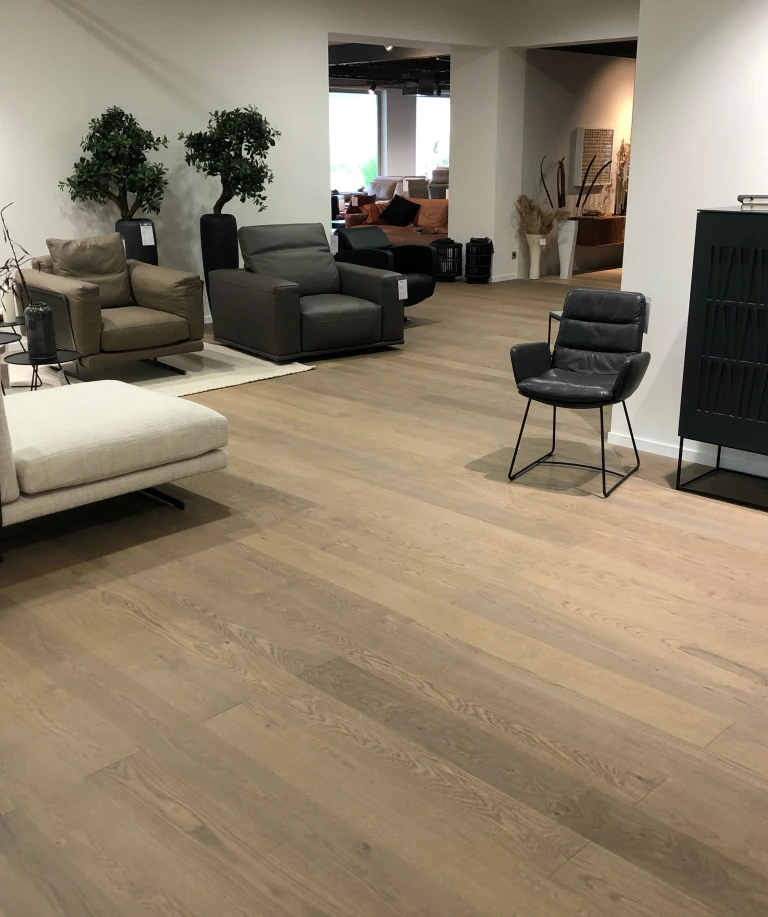 Die graue Anmutung des Parkettbodens bildet attraktive Kontraste mit den kräftigen Farben der Möbel und Sitzmöbel.