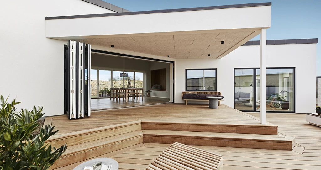 Ferievillaens højdepunkt er terrassen, der strækker sig over hele bygningens side på to niveauer.