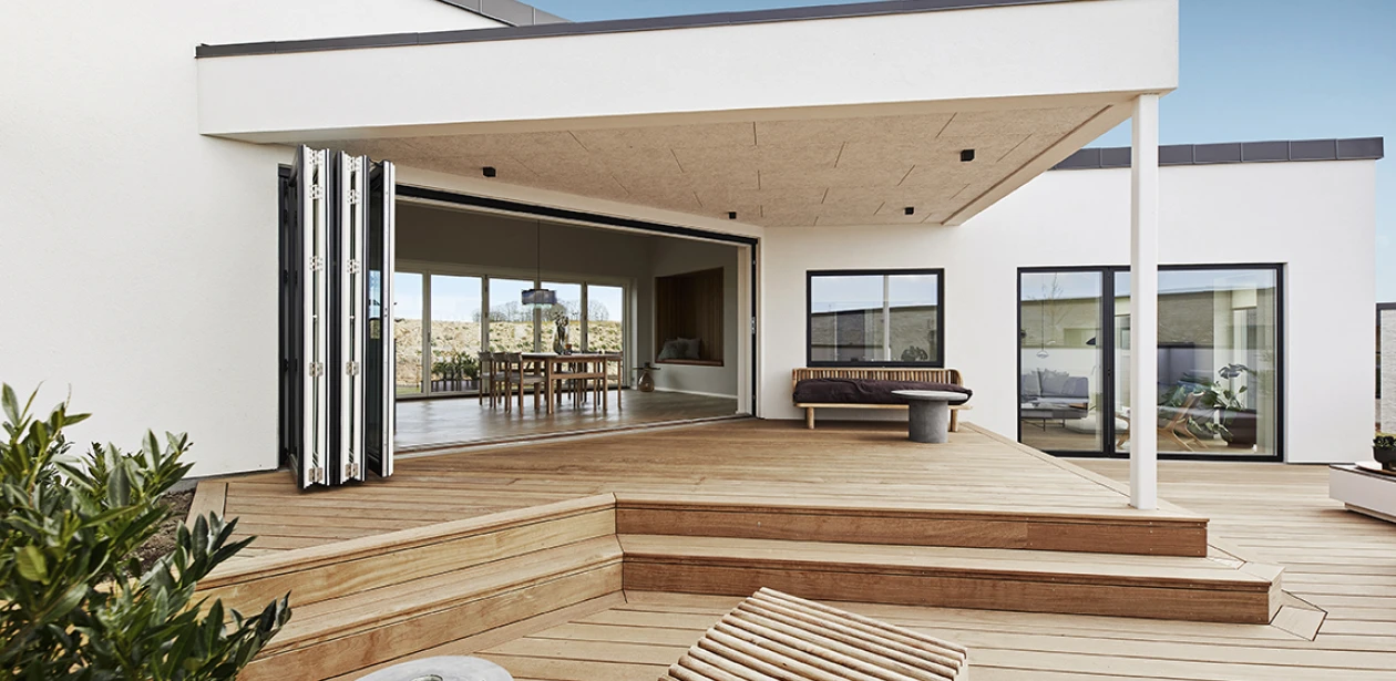 Ferievillaens højdepunkt er terrassen, der strækker sig over hele bygningens side på to niveauer.