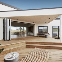 Ferievillaens højdepunkt er terrassen, der strækker sig over hele bygningens side på to niveauer.