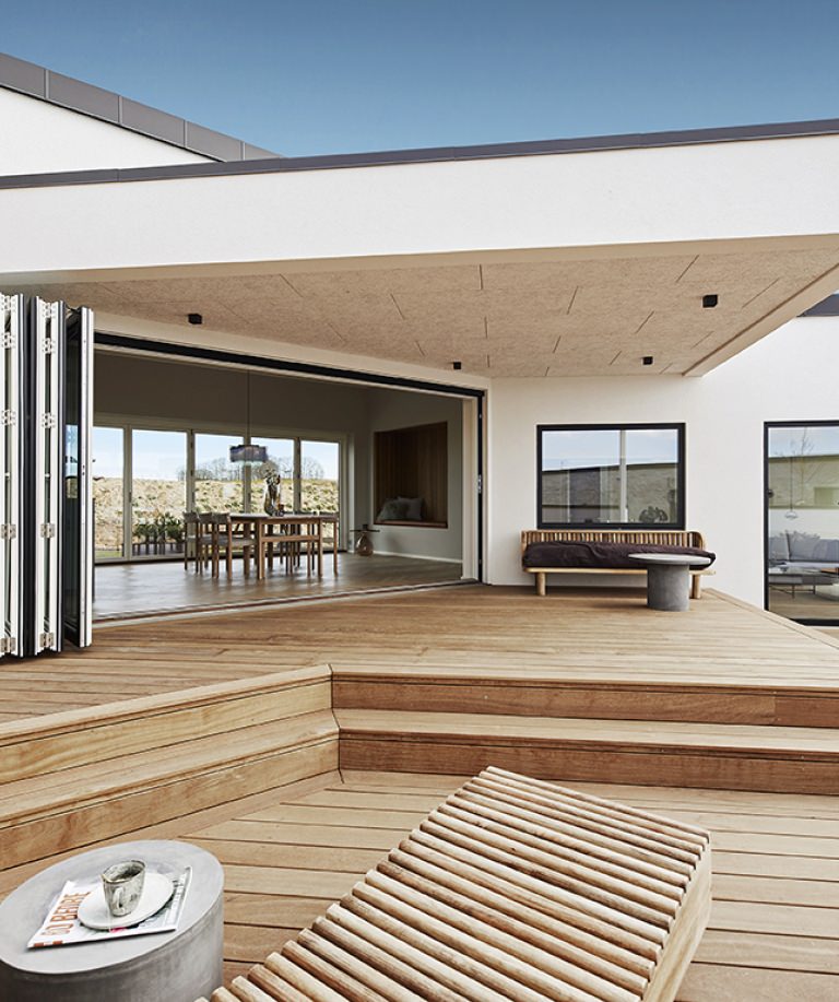 Ferievillaens højdepunkt er terrassen, der strækker sig over hele bygningens side på to niveauer.