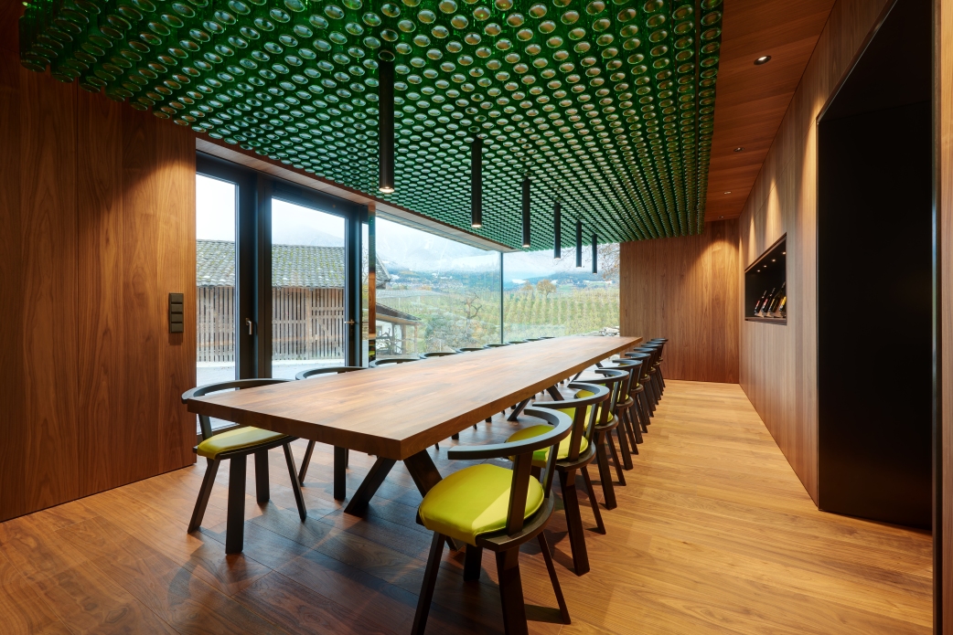 Der mächtige Tisch aus einem Nußbaum vom Hof und die Flaschen an der Decke dominieren den Raum. Der HARO Parkettboden gibt den perfekten Rahmen und vermittelt Natürlichkeit und Wärme.
